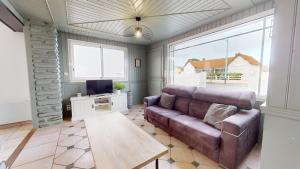 Una sala de estar con un sofá y un televisor. en Les Flots des Demoiselles, en Plage-des-Demoiselles