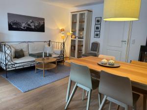 a living room with a table and a couch at Achentaler Auszeit in Schleching