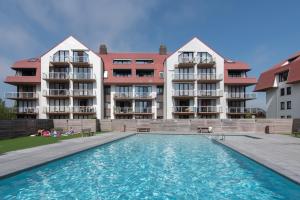 a swimming pool in front of a building at Zeewind 1 Green Garden in Middelkerke