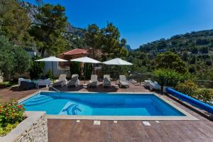 a villa with a swimming pool and a mountain at Luxurious Apartments Maslina with Beach in Milna