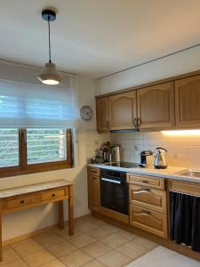 a kitchen with wooden cabinets and a black stove top oven at Apartment with a garden, close to golf in Lens +10 photos