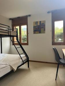 a bedroom with a bunk bed and a desk and two windows at Apartment with a garden, close to golf in Lens