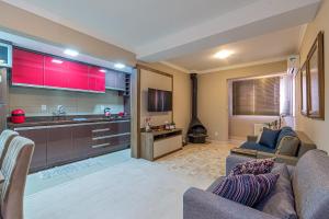 Una sala de estar con un sofá y una cocina. en Excelente no centro stayhousetemporada, en Canela