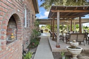 a brick building with an outdoor patio with a stone fireplace at Wine Country Oasis Private Pool & Spa in Acampo