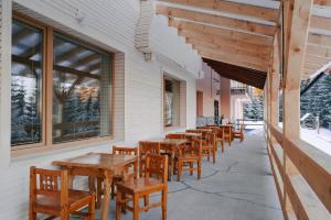 a row of wooden tables and chairs on a patio at Chata Kubínska hoľa in Dolný Kubín
