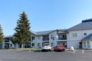 ein großes Apartmenthaus mit Autos auf einem Parkplatz in der Unterkunft Inn Building Condo 107 in Garden City