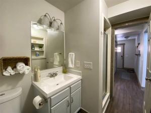 a white bathroom with a sink and a mirror at Bear Foot Beach House-Beautiful Views on the Lake in Garden City +40 photos