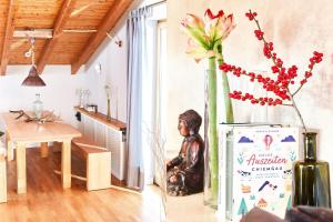 a vase with flowers in a room with a table at Übersee21 Ferienloft am Chiemsee in Übersee