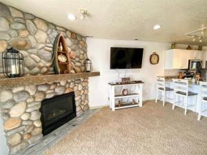 a living room with a stone fireplace and a kitchen at Beautiful Updated 2 Bedroom Condo T106 in Garden City