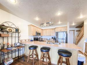 eine Küche mit Holzschränken und einer Theke mit Hockern in der Unterkunft Lake View Condo 874 4 with Awesome Lake View in Garden City