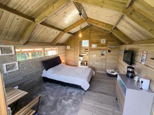 a bedroom in a wooden cabin with a bed in it at Glamping con jacuzzi La Terraza del cielo in Chocontá