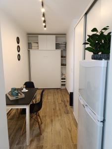 a dining room with a table and a white refrigerator at Zit Flat Colon in Mar del Plata