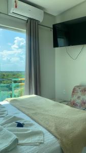Un dormitorio con una cama y una ventana grande en Hotel Grutta, en Bom Jesus da Lapa