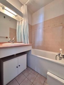 a bathroom with a sink and a bath tub at Appartement Arêches in Beaufort