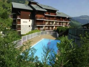 a resort with a swimming pool in front of a building at Appartement Arêches in Beaufort