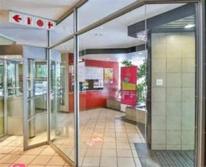 una entrada a una tienda con una puerta de cristal abierta en 50 stiemens street, en Johannesburgo