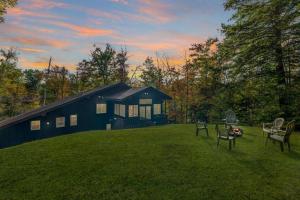 a black cabin with a table and chairs in a yard at Strasse Ski Chalet Hot Tub Dog-Friendly Skiing in Bartlett