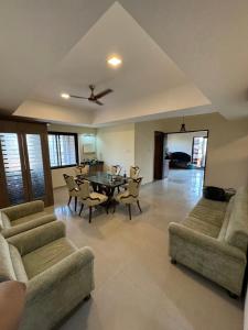 a living room with couches and a table and chairs at The Chapters in Goa