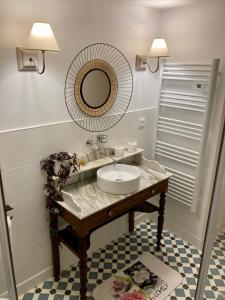 un baño con lavabo y espejo en La Maison Marguerite, en Herrère