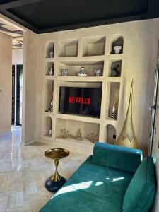 a living room with a couch and a tv on a wall at Private Riad Alemania in Marrakesh - Pool - Rooftop in Marrakech +14 photos