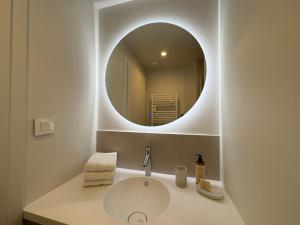 a bathroom with a white sink and a mirror at Chalet DU MERLE - CHAMP DU FEU - NEUF 5 ETOILES in Belmont