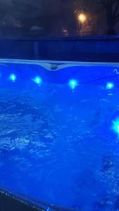 a swimming pool with blue lights in the water at Gîtes Les Grandes Voies - Clé Vacances in Le Ménil