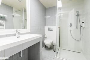 a white bathroom with a shower and a toilet at Pensiunea Terra in Bistriţa