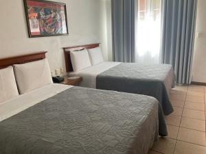 瓦哈卡市坎巴酒店的一间有两张床和一扇窗户的酒店房间