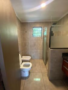 une salle de bain avec des toilettes blanches et une douche dans l'établissement Chalet Fratelli Rigoni, à Villa Ciudad Parque