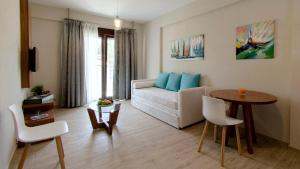a living room with a white couch and a table at Hatzoudis Luxury Suites in Chrysi Ammoudia