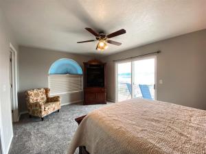 ein Schlafzimmer mit einem Deckenventilator und einem Stuhl in der Unterkunft Two Bedroom Lake View Condo 918 4, beautiful views in Garden City + 15 Fotos