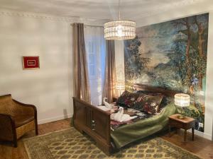 Una sala de estar con un sofá frente a un cuadro. en La Maison Marguerite, en Herrère