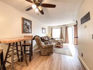 a living room with a ceiling fan and a couch at Inn Building Condo 113, Ground Level, Pool Side in Garden City