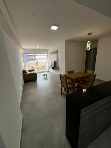 un soggiorno con un tavolo e una sala da pranzo di APARTAMENTO EM CAMBOINHA PARA TEMPORADA EM JOÃO PESSOA, A 100M DO MAR E DE FRENTE A AREIA VERMELHAa a Cabedelo Altre 2 foto