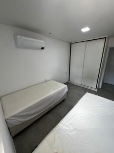 una piccola stanza con due letti e una finestra di APARTAMENTO EM CAMBOINHA PARA TEMPORADA EM JOÃO PESSOA, A 100M DO MAR E DE FRENTE A AREIA VERMELHAa a Cabedelo