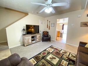 a living room with a ceiling fan and a flat screen tv at Lake View Condo 930 2 in Garden City