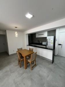 una cucina con un tavolo e sedie in legno in una stanza di APARTAMENTO EM CAMBOINHA PARA TEMPORADA EM JOÃO PESSOA, A 100M DO MAR E DE FRENTE A AREIA VERMELHAa a Cabedelo