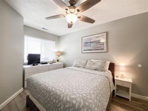 加登城Inn Building Condo 203, Remolded with Lake View的一间卧室，里面有一张床和一个吊扇 更多19张照片