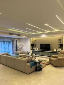 a living room with couches and a flat screen tv at فيلا فاخرة للايجار حمام سباحة التجمع الخامس in Cairo