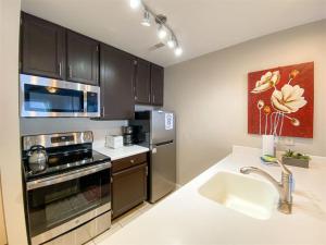 a kitchen with a sink and a stove top oven at Inn Building Condo 103 updated, pool side view in Garden City