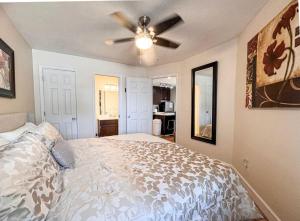 a bedroom with a bed and a ceiling fan at Inn Building Condo 103 updated, pool side view in Garden City +10 photos