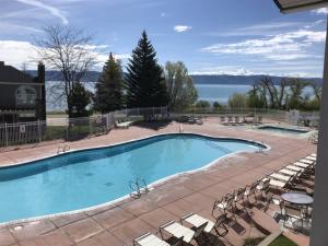 a large swimming pool with chairs and a view of the water at Inn Building Condo 103 updated, pool side view in Garden City