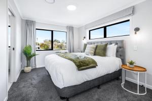 a bedroom with a large bed and two windows at Luxury, Modern with King Bed and Views- By KOSH BNB in Hamilton