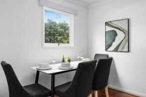 a dining room with a table and chairs and a window at Best Value 4Beds Home Near Shops, Cafes and Forest in Brisbane