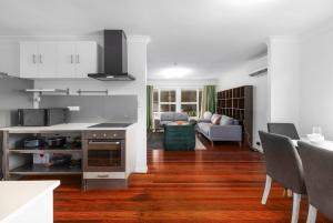 a kitchen and living room with a couch and a table at Best Value 4Beds Home Near Shops, Cafes and Forest in Brisbane
