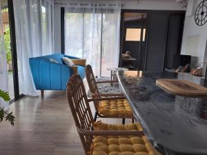 a living room with a table and chairs and a couch at Ti Kaz Luxuriante - Jacuzzi Privé - Évasion Tropicale & Intimité in Saint-Louis