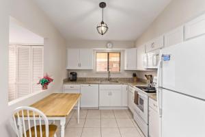 a kitchen with white cabinets and a wooden counter top at Relaxing 2BR plus Den Golf Retreat with Backyard and BBQ in Sun City