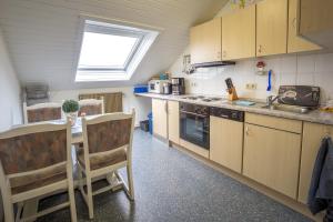 een keuken met houten kasten, een wastafel en een raam bij Apartment Preising in Willingen