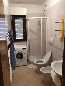 a bathroom with a toilet and a washing machine at Soffio di mare in Alba Adriatica