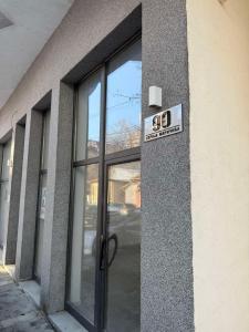 a glass door of a building with a sign on it at Urban Apartman-privatan parking- in Kraljevo